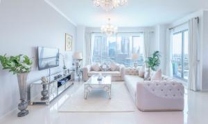 sala de estar con sofá rosa y TV en Elite Royal Apartment - Full Burj Khalifa & Fountain View - Premier - 2 bedrooms & 1 open bedroom without partition en Dubái