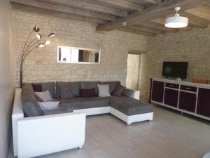 ein Wohnzimmer mit einem Sofa und einem TV in der Unterkunft LES 3 PETITS COCHONS in Le Bouchet