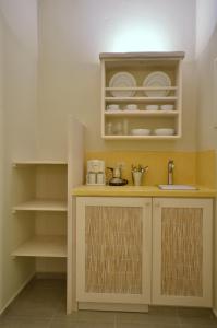a kitchen with a counter with a sink and shelves at Portes Houses in Koufonisia