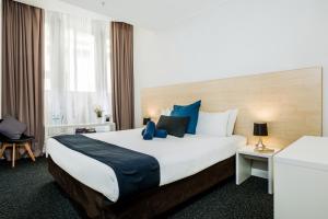 a hotel room with a bed and a desk at Nomads Sydney in Sydney
