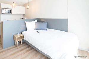 1 dormitorio con 1 cama grande y pared azul en City Studios, en Heidenheim an der Brenz