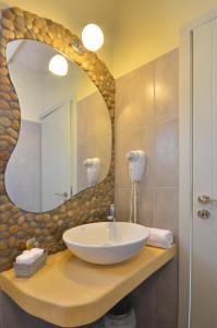 a bathroom with a sink and a large mirror at Portes Houses in Koufonisia