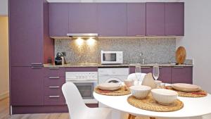a kitchen with purple cabinets and a white table at Cambrils 4 in Cambrils