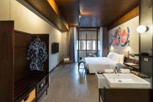 a bathroom with a bed and a sink in a room at ARTOTEL Haniman Ubud in Ubud