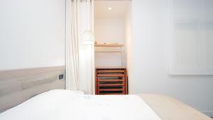 1 dormitorio con cama blanca y armario abierto en Cambrils 4, en Cambrils