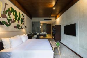 a hotel room with a bed and a television at ARTOTEL Haniman Ubud in Ubud