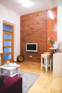 a living room with a brick wall at Clyra Apartment City Centar Zagreb in Zagreb