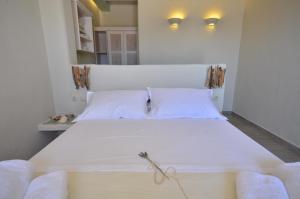 a bedroom with a large white bed with two pillows at Portes Houses in Koufonisia