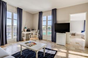 ein Wohnzimmer mit Sofa und Fernseher in der Unterkunft Le Fregate Provence in Bandol