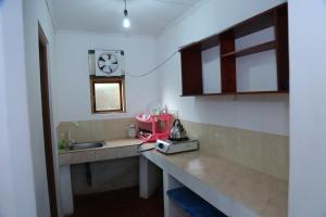 a kitchen with a sink and a clock on the wall at Holiday Home Bentota in Bentota