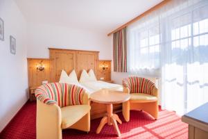 pokój hotelowy z łóżkiem i dwoma krzesłami w obiekcie Feriengut Fingerhof w mieście Flachau