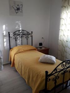 1 dormitorio con cama negra y colcha amarilla en la rosa, en Crotone