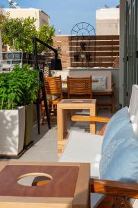 a balcony with wooden furniture and a table and chairs at Faces Art Suites in Rhodes Town