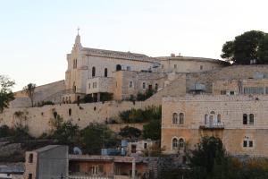 uma vista para a cidade velha de Jerusalém com uma igreja em House of Peace em Belém