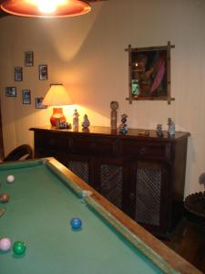a living room with a pool table and a lamp at Regina Guest House in Praia do Rosa