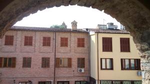 Cette chambre offre une vue sur un bâtiment en briques doté de fenêtres. dans l'établissement Il risveglio sul Giano, à Fabriano