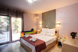a bedroom with a bed with two towels on it at ILIDA apartments in Nea Peramos