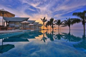 a swimming pool with palm trees and a resort at Laya Safari Resorts & Spa in Yala