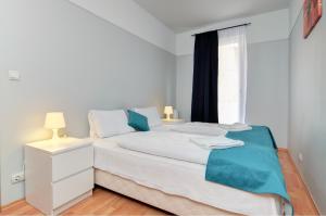 1 dormitorio con cama blanca y ventana en Agape Apartments, en Budapest