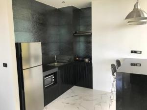 a black and white kitchen with a refrigerator and a sink at Lennon Maison in Mae Nam