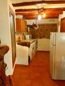 cocina con nevera blanca y fogones en Casa rural el turmell, en Chert