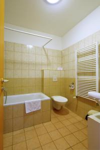 La salle de bains est pourvue d'une baignoire, de toilettes et d'un lavabo. dans l'établissement Agape Apartments, à Budapest