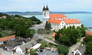 a town with a large building with a clock tower at Marta Guest House in Gyenesdiás