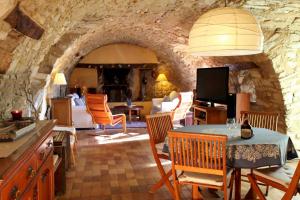 SigonceにあるLa Colle en Provence Main Houseの石壁のリビングルームとキッチンが備わります。