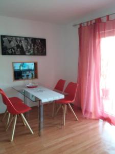 a dining room with a table and red chairs at Ferienwohnung Andrea in Eberbach +4 photos