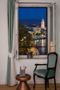 a window with a chair and a view of the water at Belvedere Luxury Rooms - Breathtaking View in Split