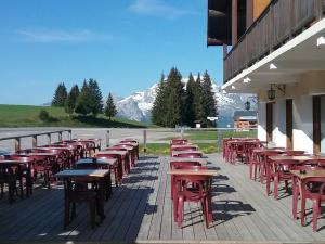 a row of tables and chairs outside of a building at Hotel Restaurant Les Rosieres in Manigod