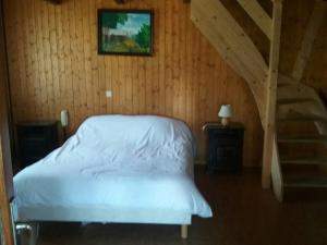 a bedroom with a white bed and a staircase at Hotel Restaurant Les Rosieres in Manigod