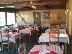 a dining room with tables and chairs with red and white linens at Hotel Restaurant Les Rosieres in Manigod +14 photos