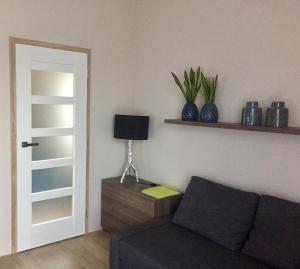 ein Wohnzimmer mit einem Sofa und einem Tisch mit einer Lampe in der Unterkunft Modrý Apartmán in Dolní Morava