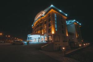 a large building with a sign on it at night at Karpalas City Hotel & Spa in Bolu