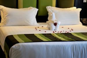 um bicho de peluche sentado em cima de uma cama em Best Western Premier Garden Hotel Entebbe em Entebbe