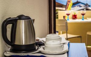 a tea kettle on a table with glasses of wine at Aeromar in Faro