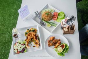 a white table with plates of food on it at Shafa Resort in Mae Sot