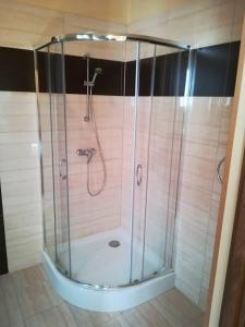 una doccia con porta in vetro in bagno di Hotel Polonia a Nowa Sól