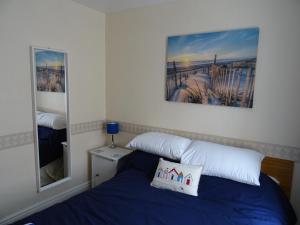 een slaapkamer met een bed en een spiegel bij Glendowie Hotel in Blackpool