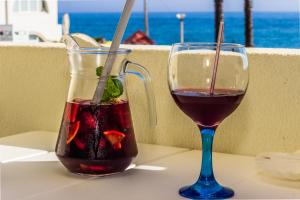 a glass of wine and a vase with a drink at Aeromar Beach Hotel in Faro