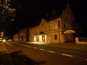 an empty city street at night with a building at Hotel Polonia in Nowa Sól