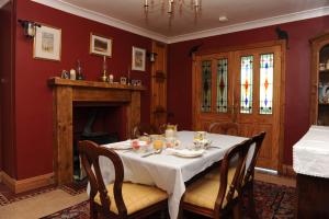 uma sala de jantar com uma mesa e uma lareira em Bay Cottage Bed & Breakfast em Crumlin