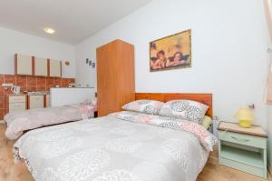 a bedroom with two beds and a kitchen at Apartments Ivana in Nin