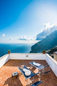 a balcony with two tables and a view of the ocean at YourHome - Casa Sansone Positano in Positano