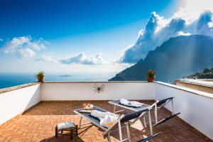 a balcony with a table and chairs on the roof at YourHome - Casa Sansone Positano in Positano