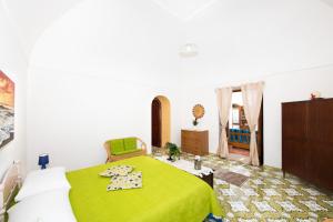 a bedroom with a bed with a green blanket at YourHome - Casa Sansone Positano in Positano