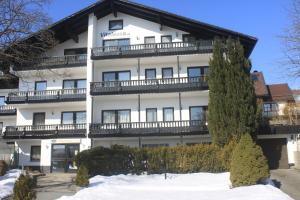 um grande edifício branco com neve em frente em Vitalesca em Neuschönau