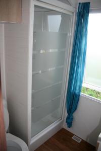 a shower in a bathroom with a blue curtain at Logis de l'Aubonnière in Chaille sous les Ormeaux