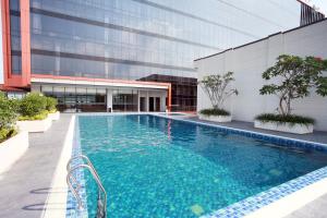 a swimming pool in front of a building at Grand Karlita Hotel Purwokerto in Purwokerto